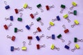 Metal binder colorful clips on violet background, office and school stationery Royalty Free Stock Photo