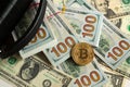 Metal bitcoin cripto money and black bag on American dollar banknotes