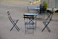 Metal black chairs and tables in a cafe on a cobbled square. everything is made of light material that can be folded and cleaned e Royalty Free Stock Photo