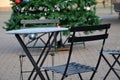 Metal black chairs and tables in a cafe on a cobbled square. everything is made of light material that can be folded and cleaned e Royalty Free Stock Photo