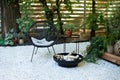 Metal black fireplace bowl in garden on back yard patio. Outdoor patio furniture on pebbles in a front garden. Front veranda of ho