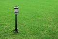 Metal black street lamp on green grass