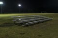 Metal bleachers on an empty soccer field at night