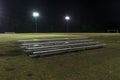 Metal bleachers on an empty soccer field at night