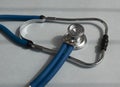 Metal blue sthethoscope on gray desk, close up Royalty Free Stock Photo