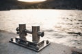 Metal bollard for boats and vessels on wharf over sea and sunset background close up.