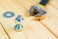 Metal bolts and nuts on wooden background with adjustable wrench