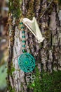 Metal bookmark with dreamcatcher handmade on the bark tree