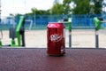 A metal bottle of Dr Pepper drink on the background of a street sports ground.