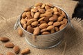 Metal bowl full of almonds on a sackcloth. Pile of nuts stacked together randomly on the burlap background. Healthy nutrition Royalty Free Stock Photo