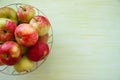 Metal bowl with green, yellow and red apples on the left side on the green wooden background. Royalty Free Stock Photo