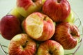 Metal bowl with green, yellow and red apples and one bitten apple closeup. Royalty Free Stock Photo