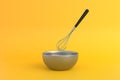 Metal bowl with whisk for preparation of dough on yellow background Royalty Free Stock Photo