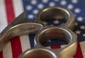 A metal brass knuckles lies against the background of the American flag. Concept: prohibited and permitted use of cold weapons, cr