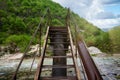 Metal bridge over mountain river Royalty Free Stock Photo