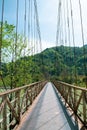 Narrow metal bridge over a mountain river. Royalty Free Stock Photo