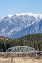 metal bridge over a river with mountain in snow in the background Regional District of East Kootenay Canada Royalty Free Stock Photo