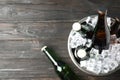 Metal bucket with bottles of beer and ice cubes on wooden background, top view. Space for text Royalty Free Stock Photo