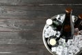 Metal bucket with bottles of beer and ice cubes on wooden background, top view. Space for text Royalty Free Stock Photo