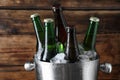 Metal bucket with bottles of beer and ice cubes on wooden background, closeup Royalty Free Stock Photo