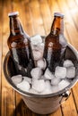 A metal bucket is filled with ice, and two glass bottles of beer Royalty Free Stock Photo
