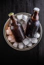 A metal bucket is filled with ice, and two glass bottles of beer Royalty Free Stock Photo