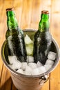 A metal bucket is filled with ice, and two glass bottles of beer Royalty Free Stock Photo