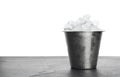 Metal bucket with ice cubes on table against background Royalty Free Stock Photo