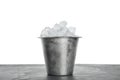 Metal bucket with ice cubes on table against background Royalty Free Stock Photo