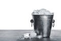 Metal bucket with ice cubes on table against background Royalty Free Stock Photo