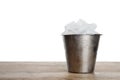 Metal bucket with ice cubes on table against white background Royalty Free Stock Photo