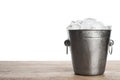 Metal bucket with ice cubes on table against white background Royalty Free Stock Photo