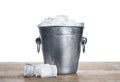 Metal bucket with ice cubes on table against white background Royalty Free Stock Photo