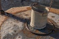 Metal bucket on an old stone well closed with a metal lid