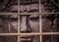 A metal buddha sculpture with wood on front of it