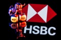 Metal bull stands on buy-sell dices on background of HSBC bank logo