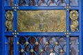 Metal bumblebee and flowers decorating the ornate blue door