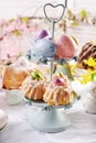 Metal cake stand with Easter mini ring cakes and colored eggs