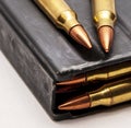 A metal 223 caliber rifle magazine loaded with 223 caliber bullets with two bullets on top of it Royalty Free Stock Photo