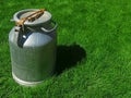 Metal can for milk with a closed lid. in sunny weather on the grass. the idea is a healthy diet. empty space for text. Royalty Free Stock Photo