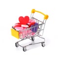 a metal cart filled with multicolored differently shaped hearts on a white isolated background