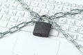 Metal chain and padlock close-up on the background of a white laptop keyboard Royalty Free Stock Photo