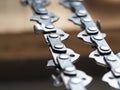 Metal chainsaw chain with sharp teeth with blurred background