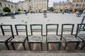 Metal chairs on cobbled street in art installation of city