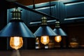 Metal chandeliers in retro style on the background of the kitchen set. Dark room with brightly lit lamps