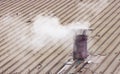 Metal chimney on copper roof with smoke - image with copy space