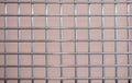 Metal chrome grate with a square mesh on a pink background Royalty Free Stock Photo