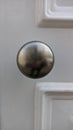 Metal chrome handle on white wooden door Royalty Free Stock Photo