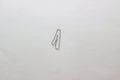 A metal clip in the form of the number one on a white sheet of Whatman paper. Paper clip isolate on a white background Royalty Free Stock Photo
