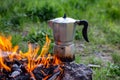 Metal coffee maker on an open fire in nature. Making coffee. Camping in summer Royalty Free Stock Photo